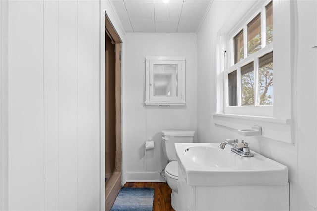 bathroom featuring hardwood / wood-style floors, toilet, and crown molding