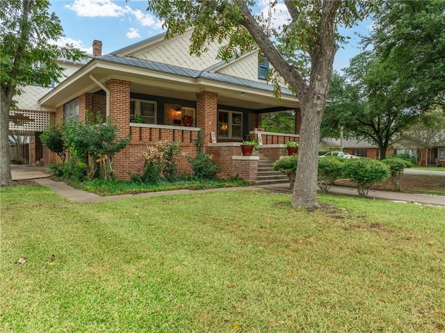 view of front of house featuring covered porch and a front yard