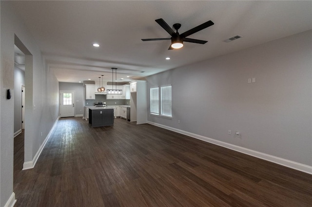 unfurnished living room featuring dark hardwood / wood-style flooring and ceiling fan