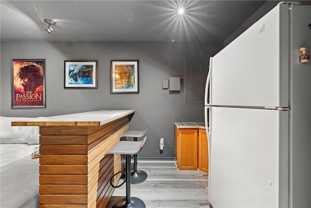 bar featuring white fridge and light hardwood / wood-style floors