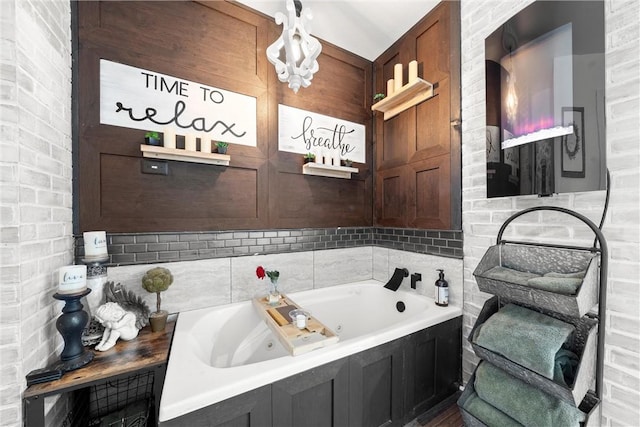 bathroom featuring a tub and brick wall