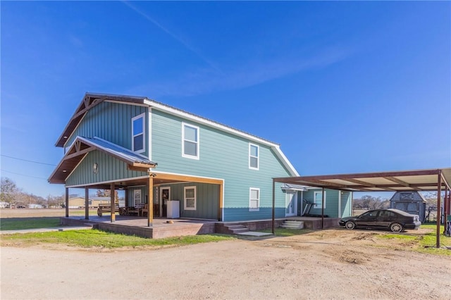 rear view of property with covered porch and a carport