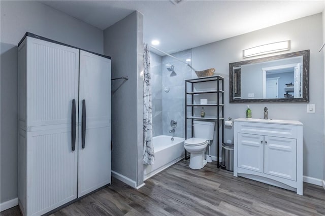 full bathroom featuring toilet, hardwood / wood-style floors, vanity, and tiled shower / bath