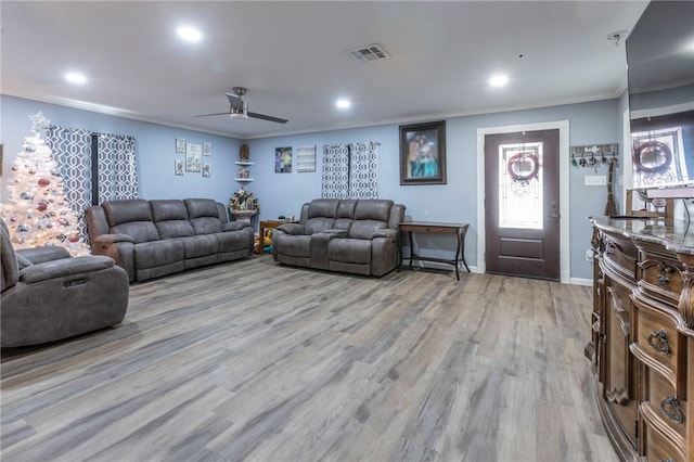 living room featuring light hardwood / wood-style floors, ceiling fan, and ornamental molding