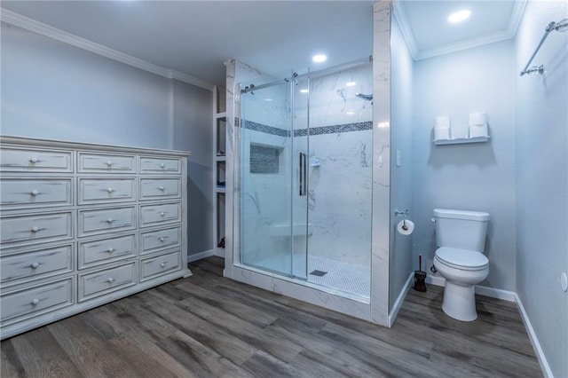 bathroom with hardwood / wood-style floors, toilet, ornamental molding, and a shower with shower door