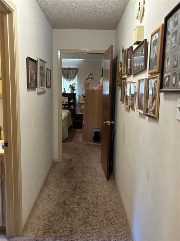 hallway featuring carpet floors and a textured ceiling