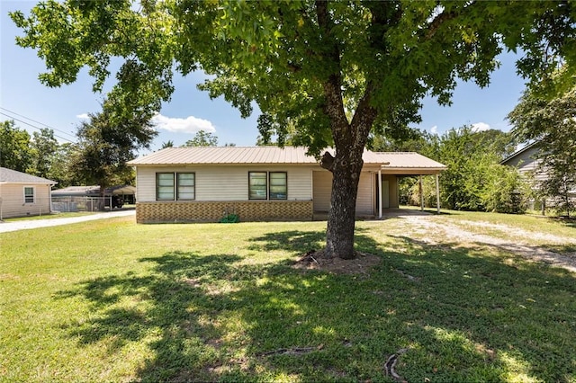 ranch-style house featuring a carport and a front yard