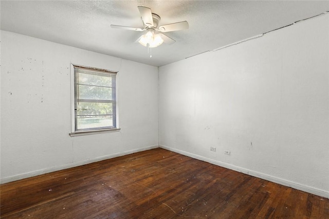 empty room with dark hardwood / wood-style flooring and ceiling fan