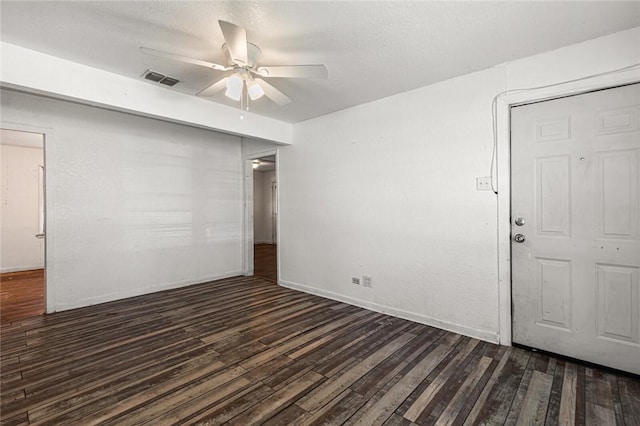 empty room featuring ceiling fan and dark hardwood / wood-style flooring