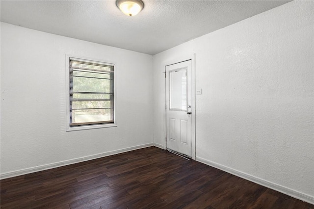 spare room with dark wood-type flooring