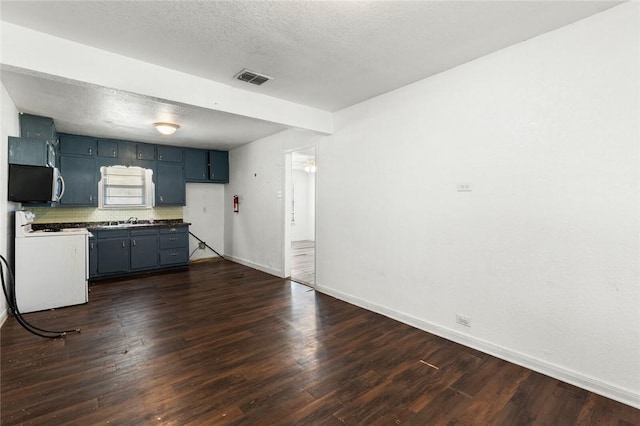 kitchen featuring sink, dark hardwood / wood-style floors, white range, backsplash, and a textured ceiling