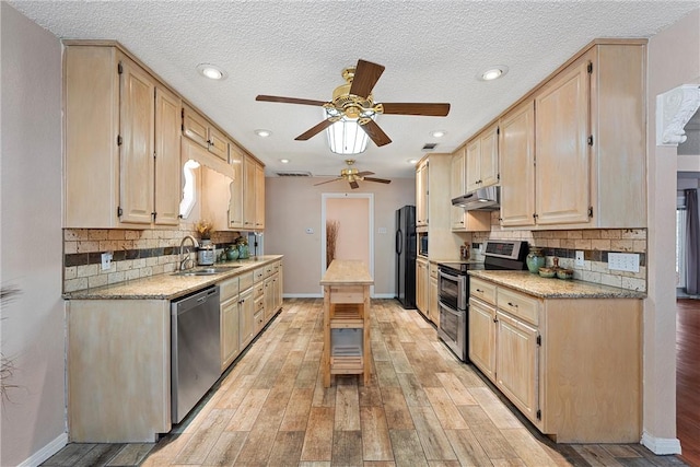 kitchen with sink, light hardwood / wood-style flooring, a textured ceiling, light brown cabinetry, and stainless steel appliances