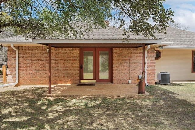 back of house featuring a lawn, central air condition unit, a patio, and french doors