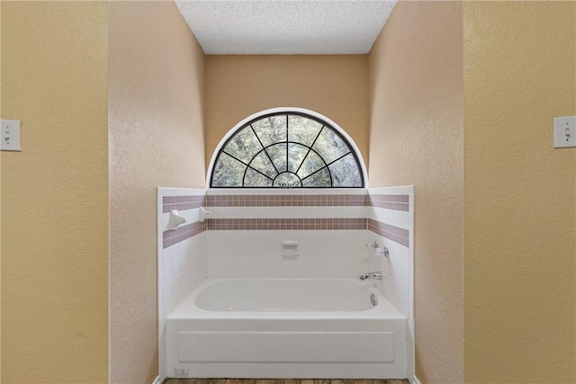 bathroom with a bathtub and a textured ceiling