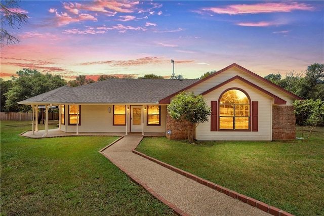 single story home with a lawn and a patio area