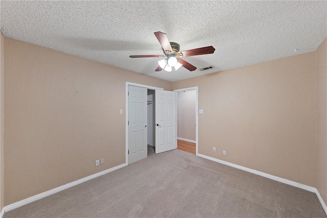 unfurnished bedroom with carpet flooring, a textured ceiling, and ceiling fan