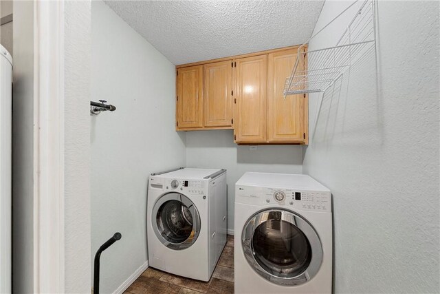 laundry area featuring cabinets, a textured ceiling, and washing machine and dryer