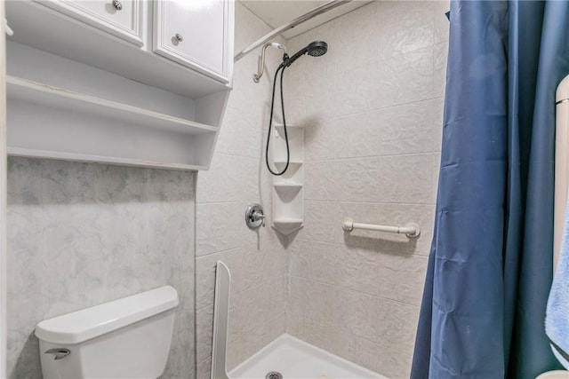 bathroom with curtained shower and toilet