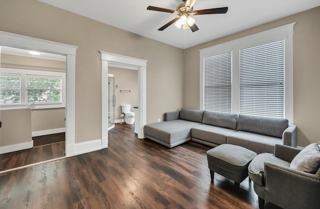 living room with dark hardwood / wood-style flooring and ceiling fan