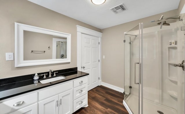 bathroom featuring a shower with shower door, wood-type flooring, and vanity