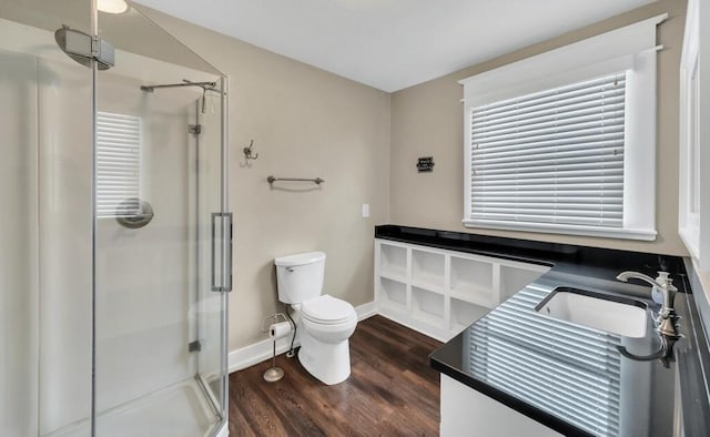 bathroom featuring hardwood / wood-style floors, vanity, toilet, and a shower with shower door