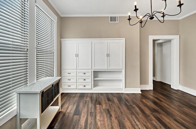 interior space featuring dark hardwood / wood-style floors, ornamental molding, and an inviting chandelier