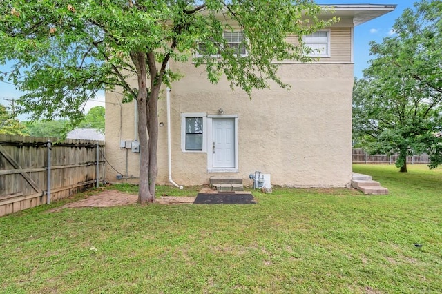 back of house featuring a lawn