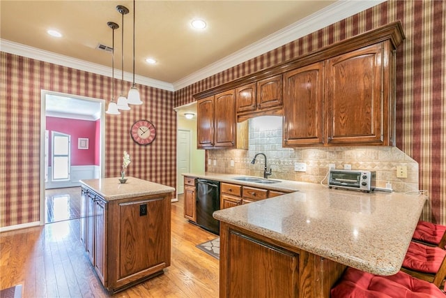 kitchen featuring dishwasher, a center island, sink, hanging light fixtures, and light hardwood / wood-style flooring