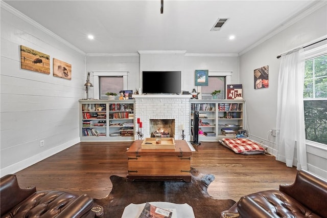 living room with crown molding, dark hardwood / wood-style floors, and a brick fireplace