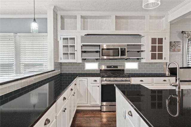 kitchen featuring appliances with stainless steel finishes, crown molding, decorative light fixtures, dark hardwood / wood-style floors, and white cabinetry