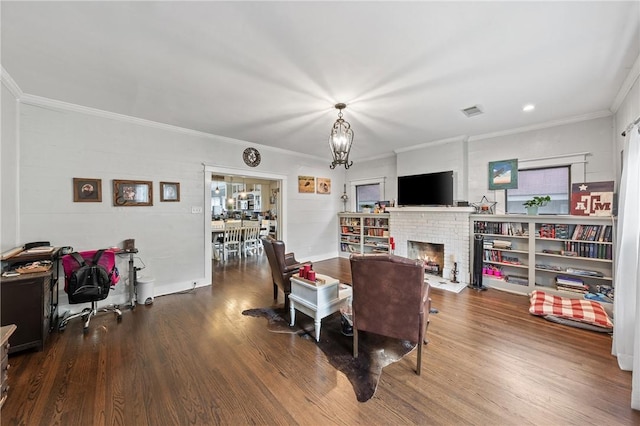 dining space with a brick fireplace, ornamental molding, and hardwood / wood-style flooring