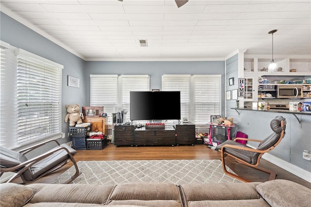 living room with hardwood / wood-style floors and crown molding