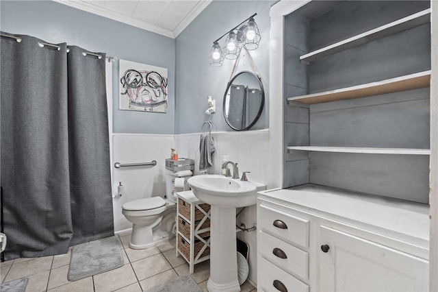 bathroom featuring toilet, tile patterned floors, crown molding, and sink