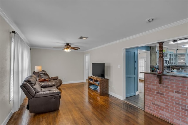 living area featuring crown molding and wood finished floors