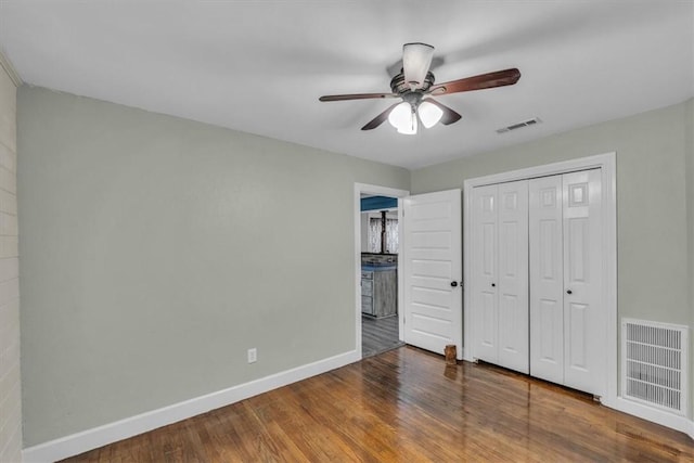 unfurnished bedroom featuring visible vents, baseboards, and wood finished floors