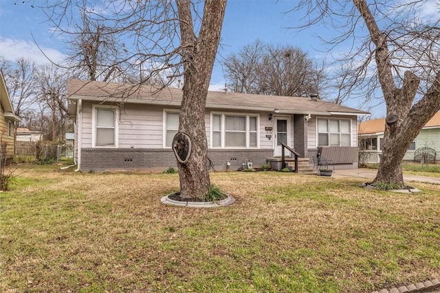 view of front facade with brick siding, a front yard, and fence