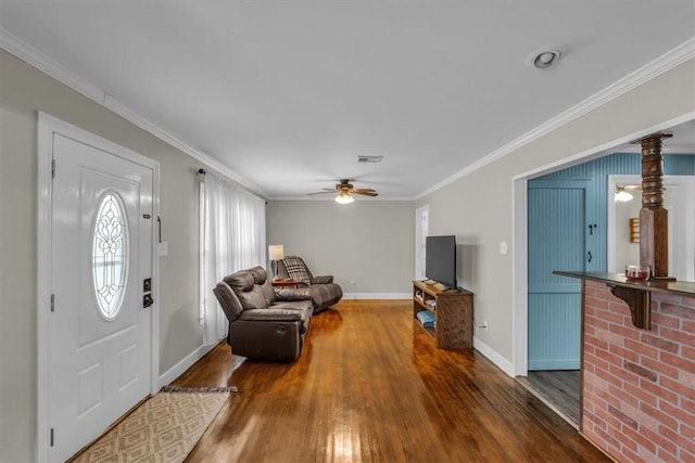 living room featuring ornamental molding, baseboards, and wood finished floors