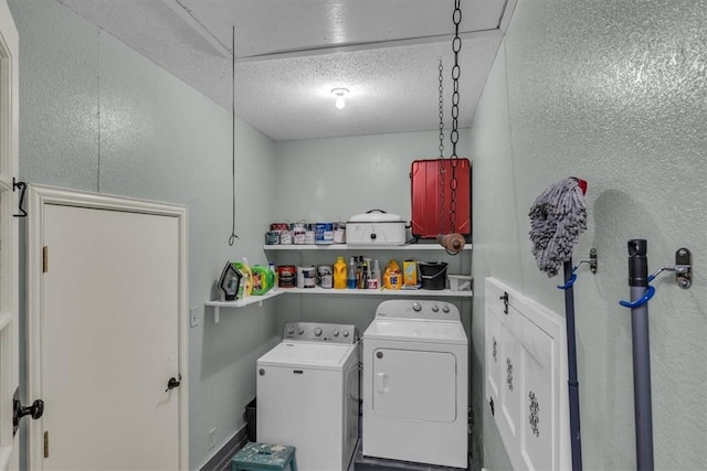 laundry area with a textured ceiling, independent washer and dryer, attic access, and laundry area