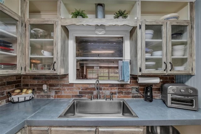 kitchen with a sink, glass insert cabinets, and a toaster