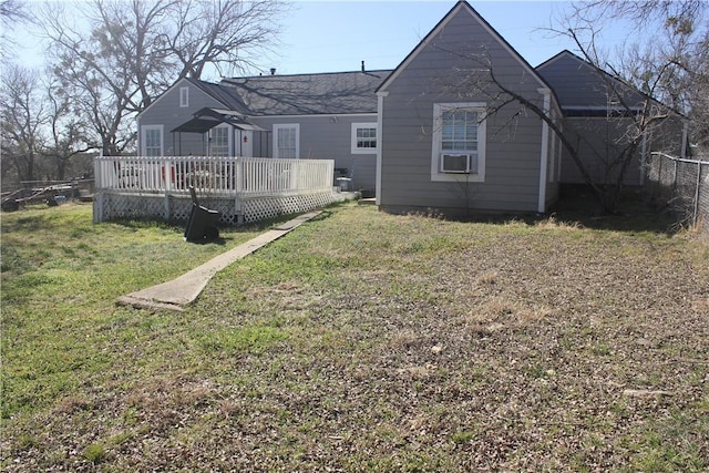 back of property featuring a wooden deck and a yard