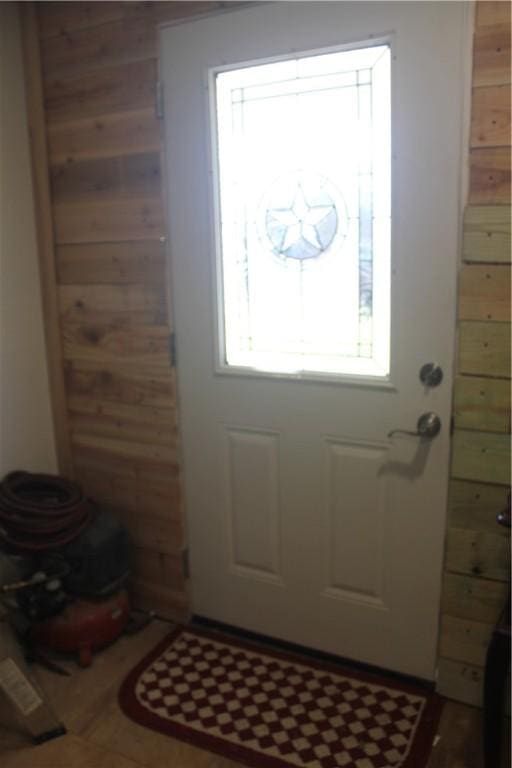 doorway featuring wooden walls