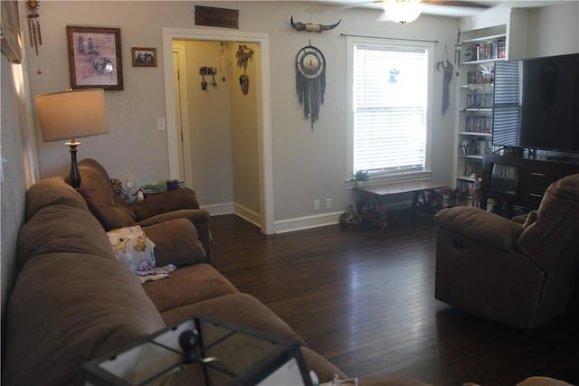 living room with dark wood-type flooring and ceiling fan