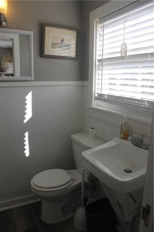 bathroom featuring toilet and tile walls