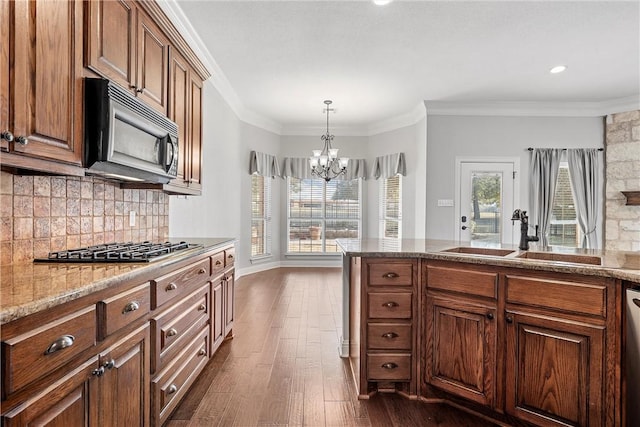 kitchen with stainless steel appliances, backsplash, dark wood-type flooring, ornamental molding, and a sink