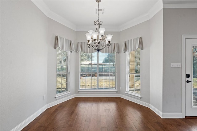 unfurnished dining area featuring wood-type flooring, visible vents, crown molding, and an inviting chandelier