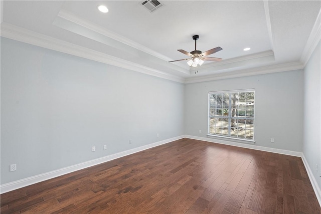 empty room featuring dark wood-style floors, a raised ceiling, visible vents, and baseboards