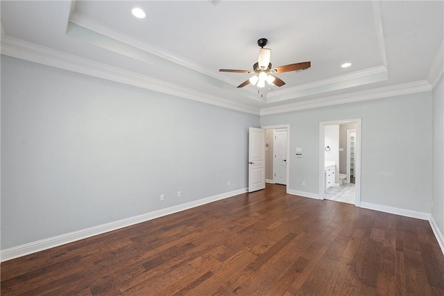 unfurnished bedroom with crown molding, wood-type flooring, a raised ceiling, and baseboards