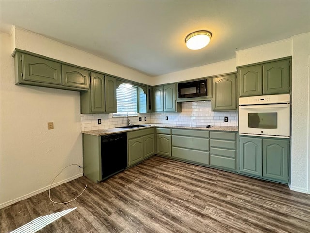 kitchen featuring dark hardwood / wood-style flooring, sink, black appliances, and green cabinetry