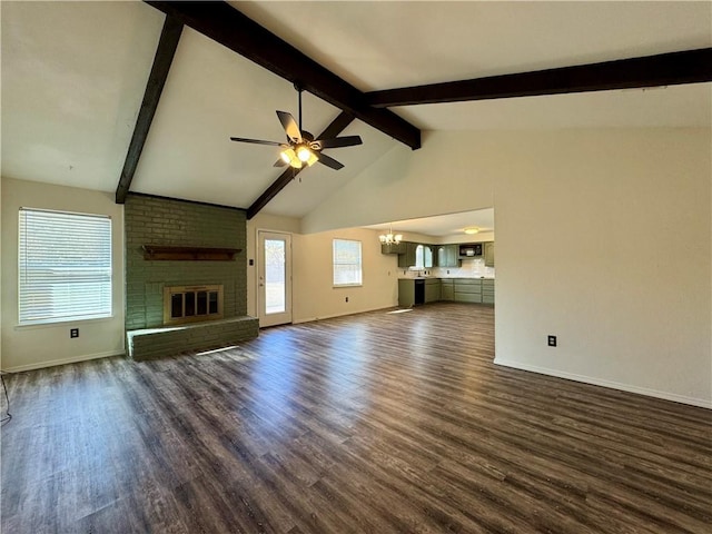 unfurnished living room with vaulted ceiling with beams, dark hardwood / wood-style flooring, ceiling fan with notable chandelier, and a brick fireplace