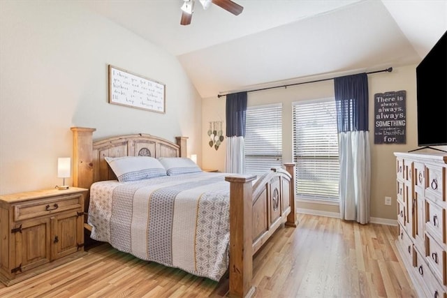 bedroom featuring ceiling fan, light wood-style flooring, baseboards, and vaulted ceiling